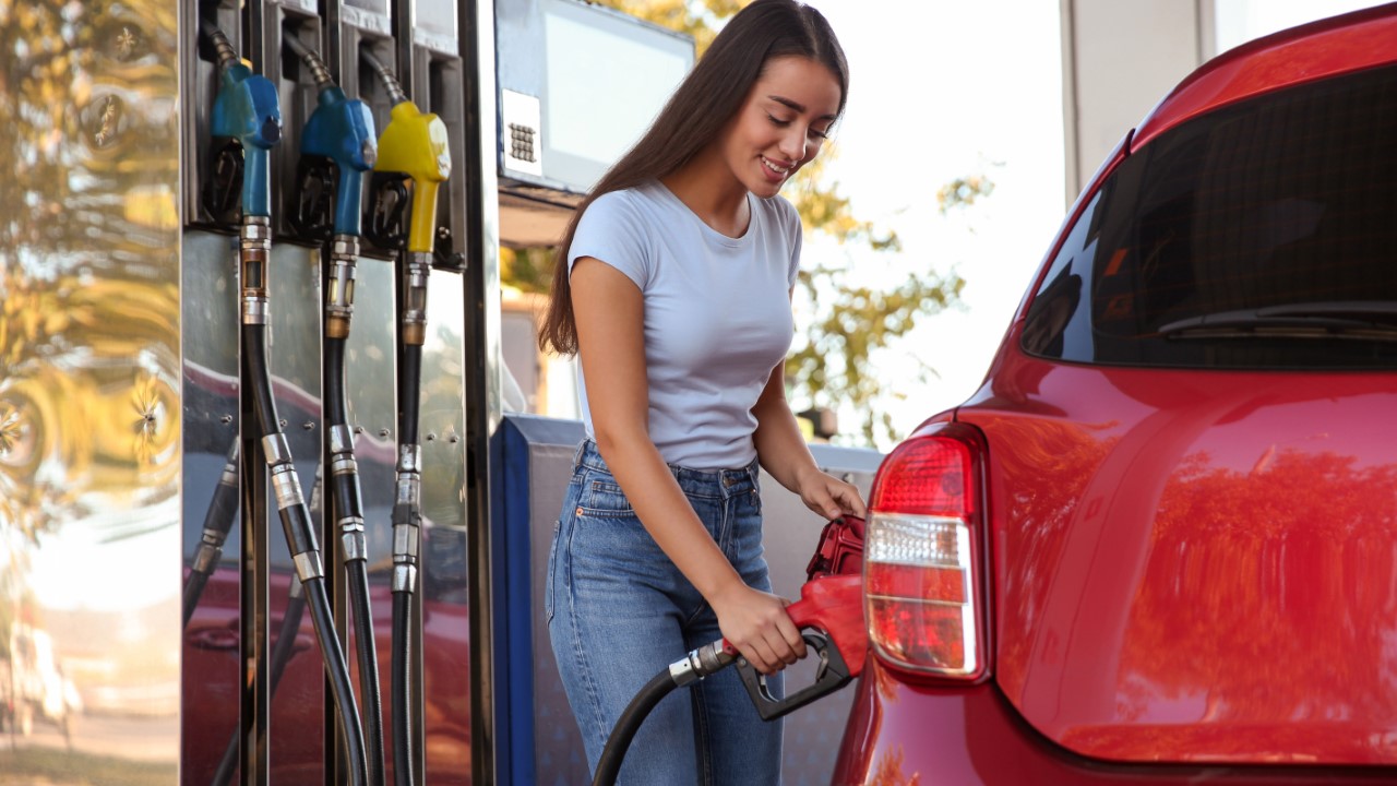 Woman pumping gas into her car
