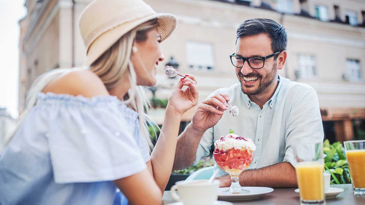 Romantic couple drinking coffee and enjoying in fruit desserts, having fun in the cafe. Dating, love, relationships