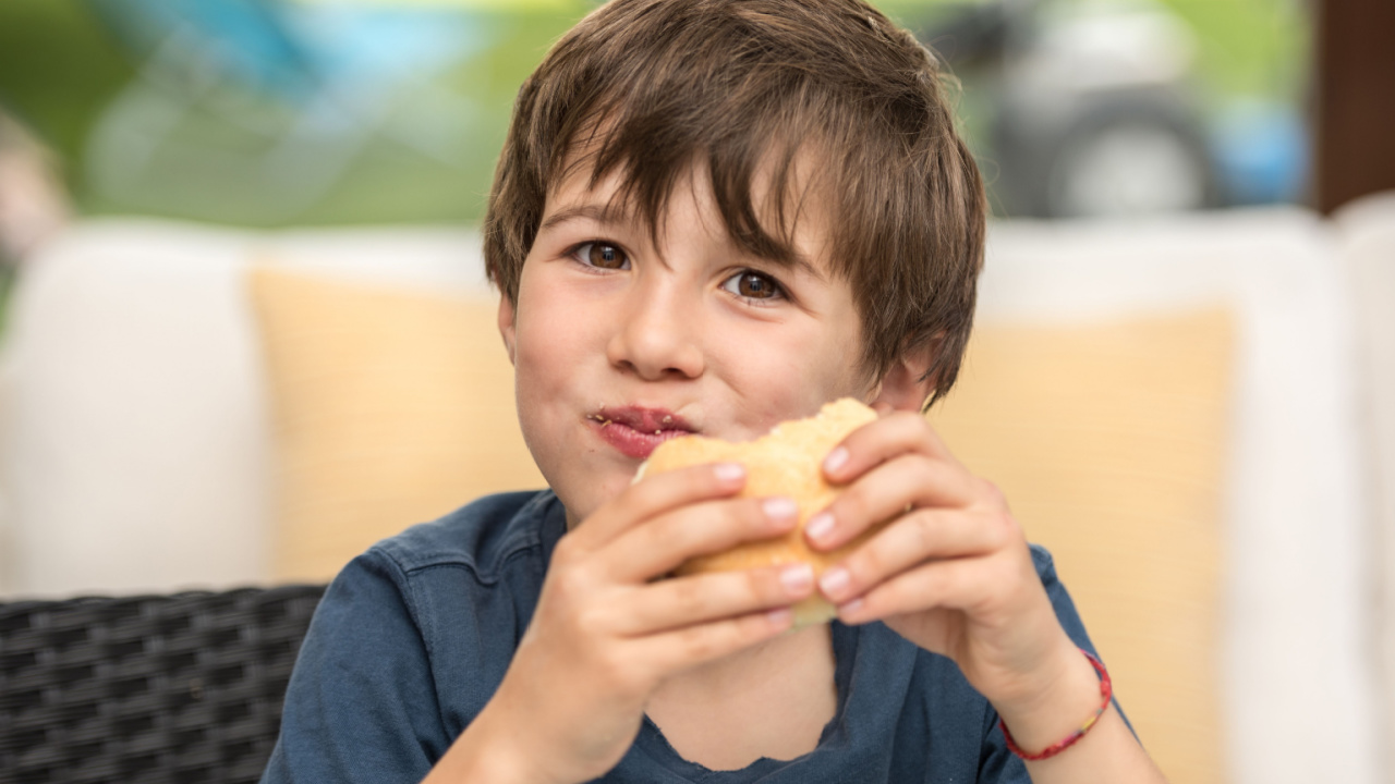 Boy eating a sandwich.