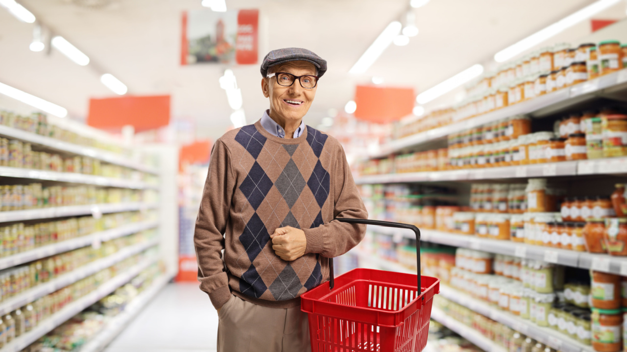 Elderly man holding shopping basket on his arm while at the supermarket