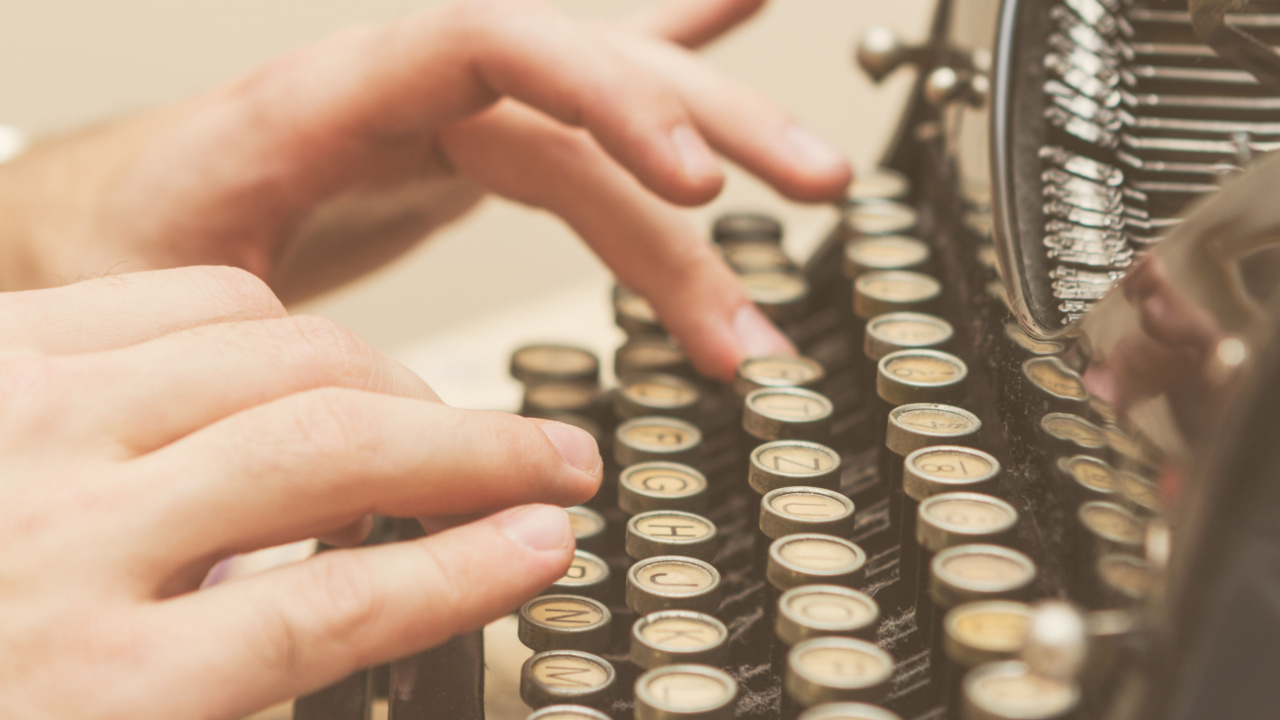 Person typing on a typewriter.