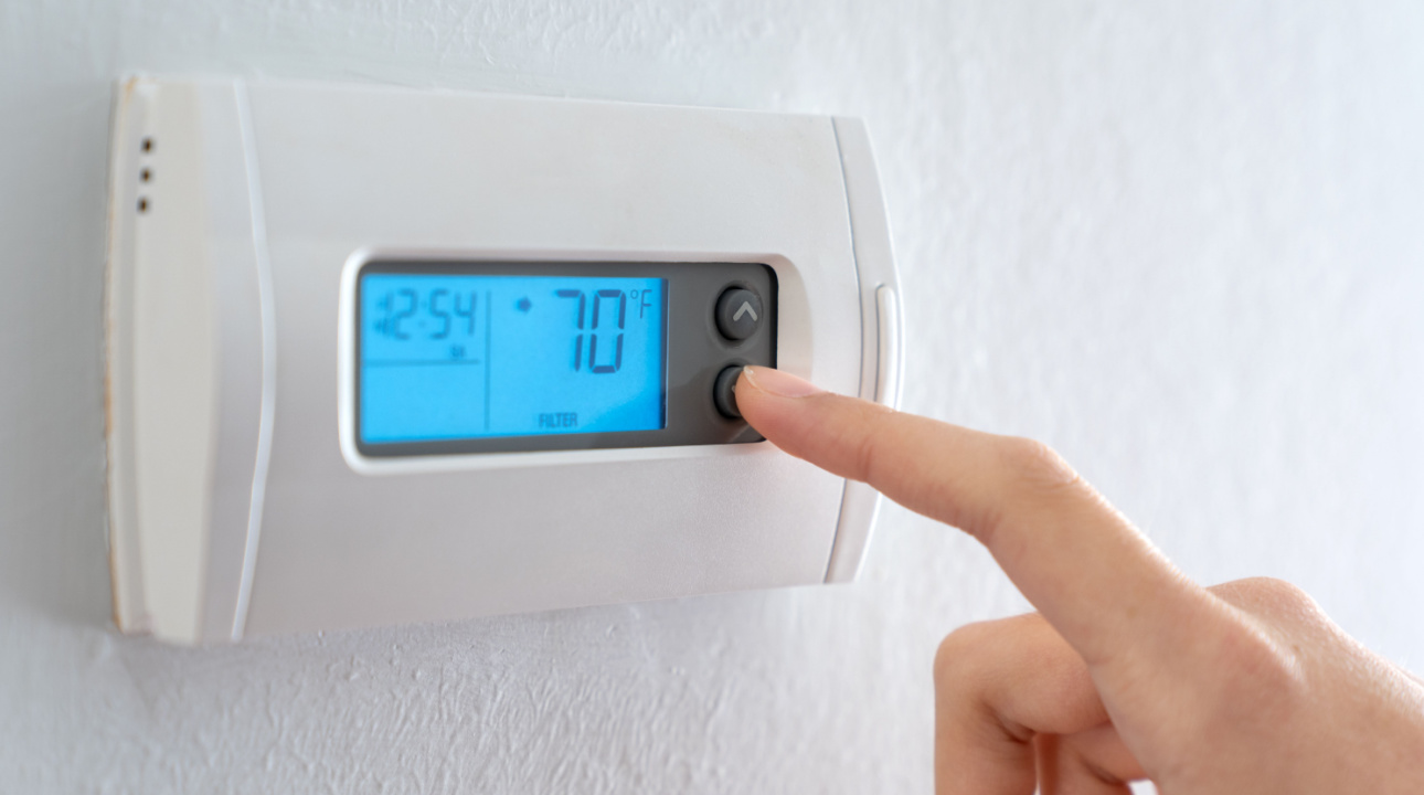 Man turning down thermostat