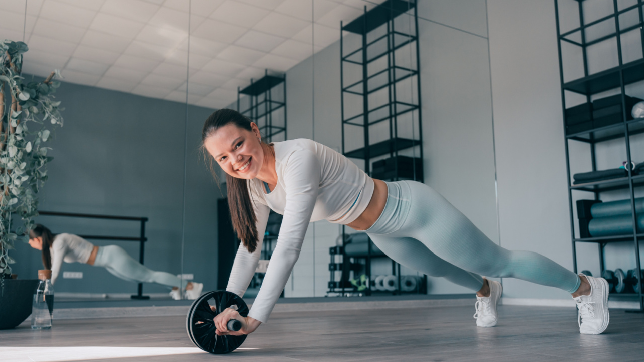 dark haired girl using an ab roller