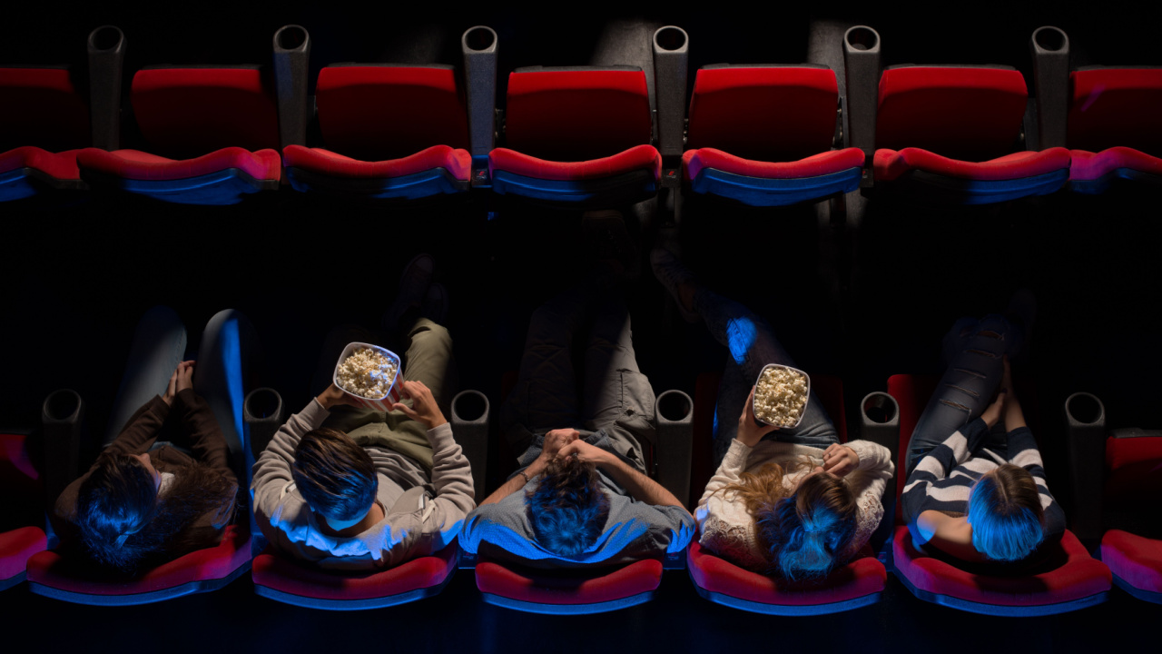 people sitting in a row in the movie theatres
