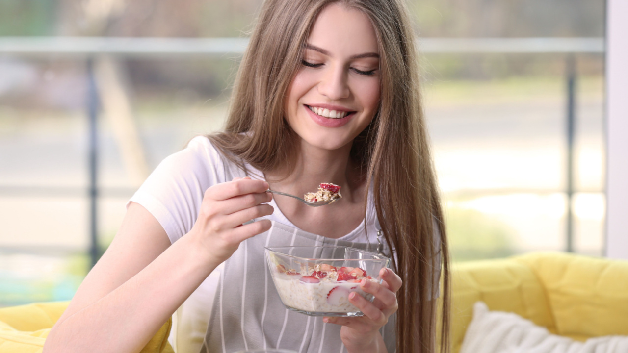 Woman eating a bowl of cereal.