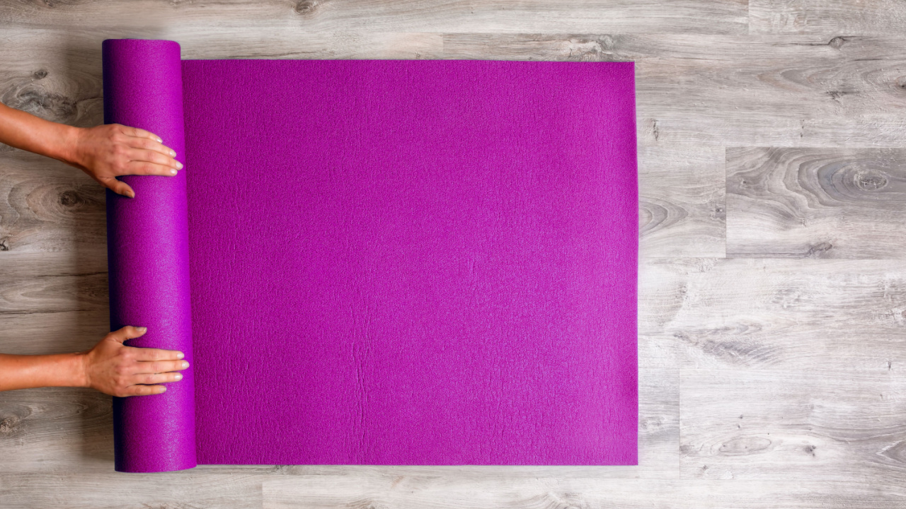 person rolling up a yoga mat