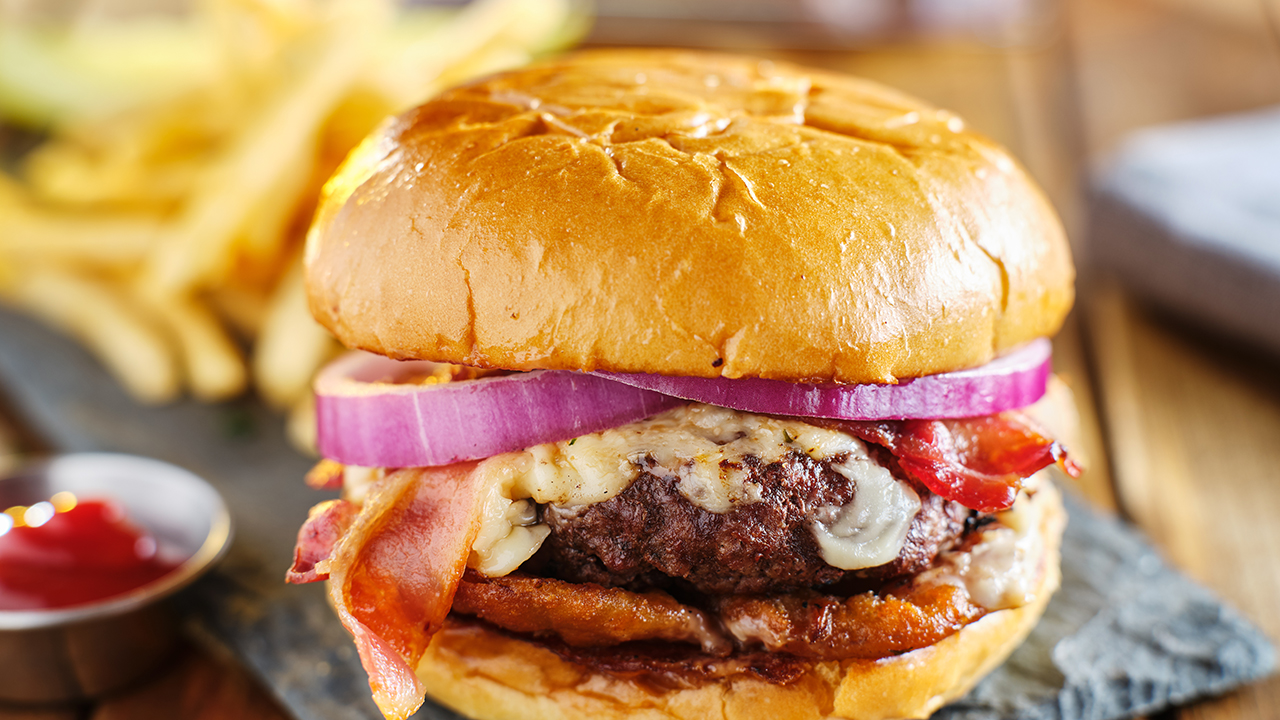 western style bacon burger with onion rings and bbq sauce