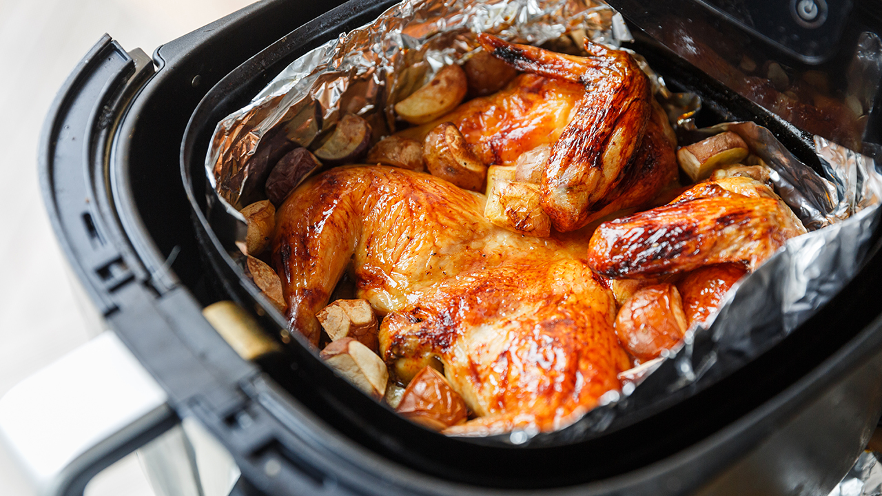 Crispy honey and lemon roasted chicken with potatoes in an air fryer under natural light