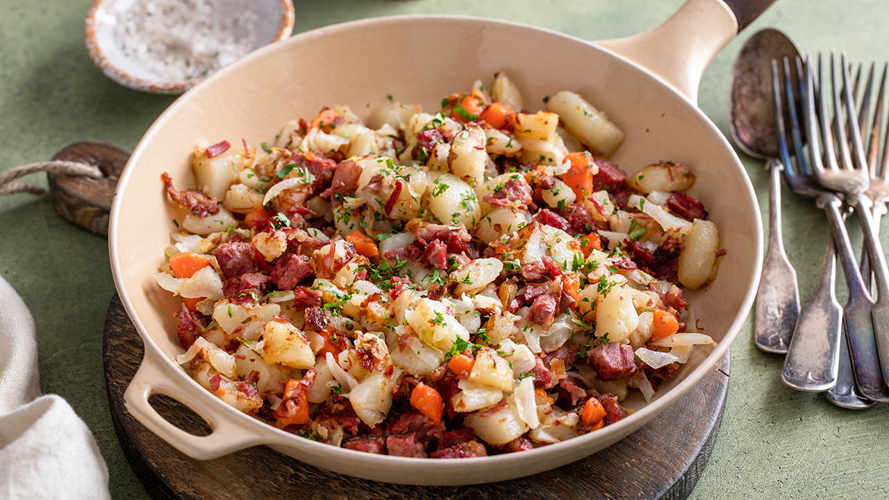 Corned beef hash with potatoes, cabbage and carrot in a cast iron pan